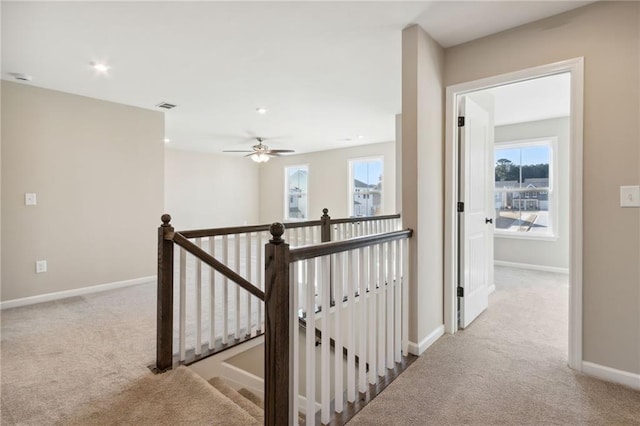 hall featuring visible vents, baseboards, recessed lighting, carpet flooring, and an upstairs landing