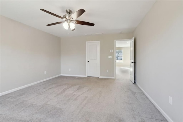 spare room featuring baseboards, a ceiling fan, and carpet flooring