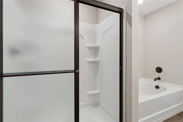 bathroom with a stall shower and a garden tub