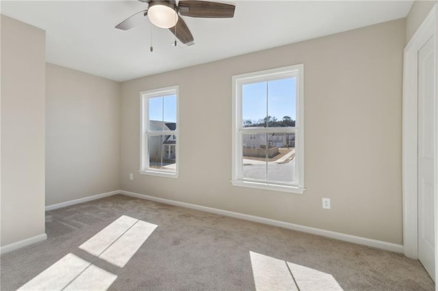 spare room featuring carpet flooring, ceiling fan, and baseboards