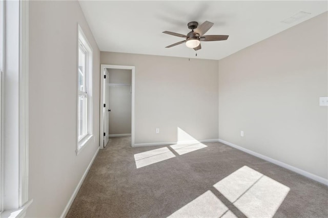 spare room with baseboards, carpet, and a ceiling fan