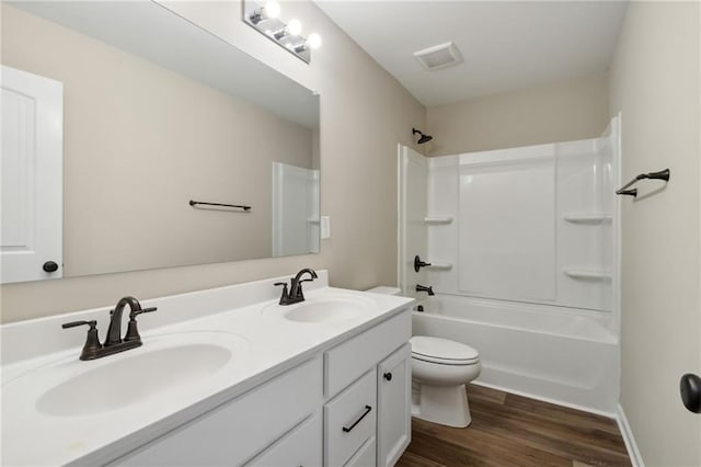 bathroom featuring visible vents, toilet, wood finished floors, and a sink