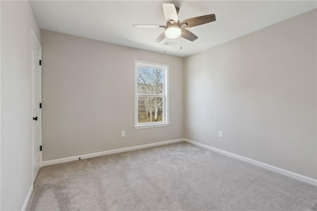 carpeted empty room with visible vents, baseboards, and ceiling fan