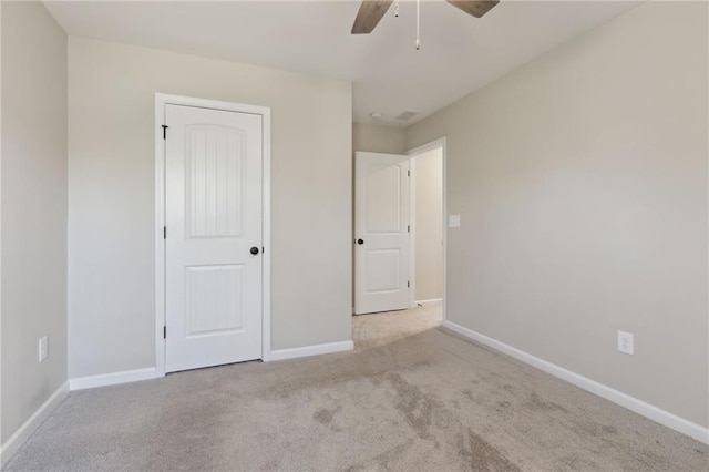 unfurnished bedroom with a closet, baseboards, carpet, and a ceiling fan