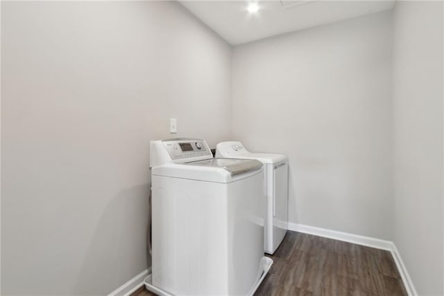 laundry room with baseboards, independent washer and dryer, dark wood finished floors, and laundry area