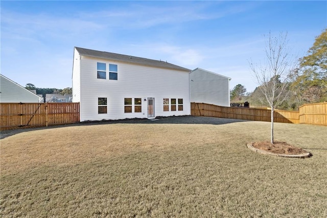 back of house featuring a yard and a fenced backyard