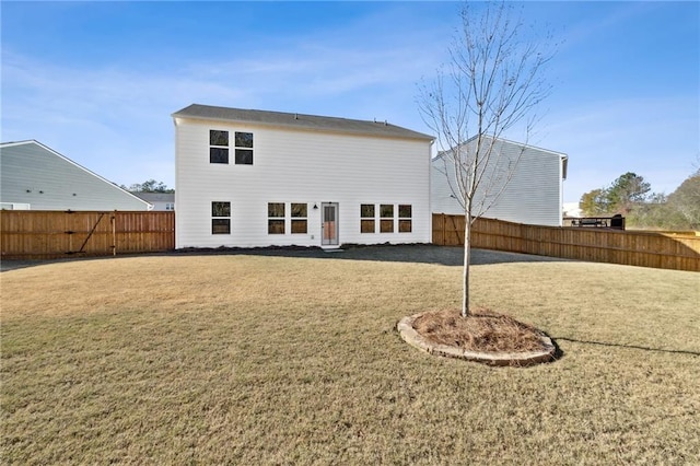 rear view of property featuring a fenced backyard and a yard