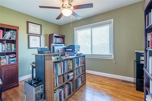 office with light hardwood / wood-style floors and ceiling fan