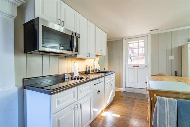 kitchen with sink, light hardwood / wood-style floors, white cabinetry, and ornamental molding