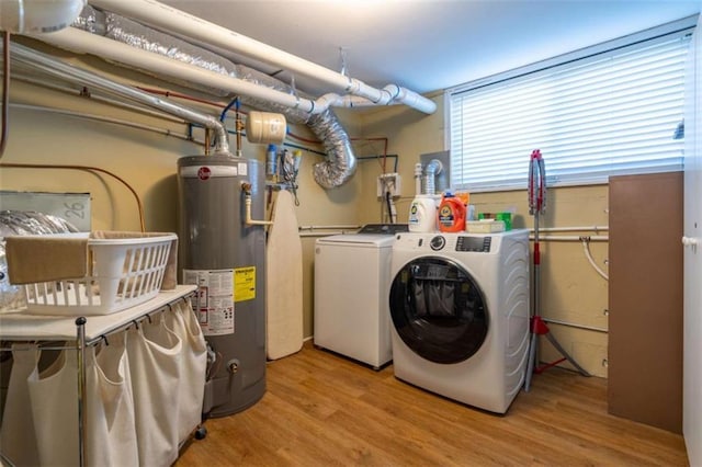 laundry area featuring light wood-type flooring, water heater, and washer and dryer