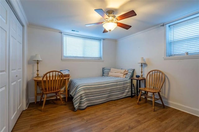 bedroom featuring a closet, ceiling fan, ornamental molding, and dark wood-type flooring