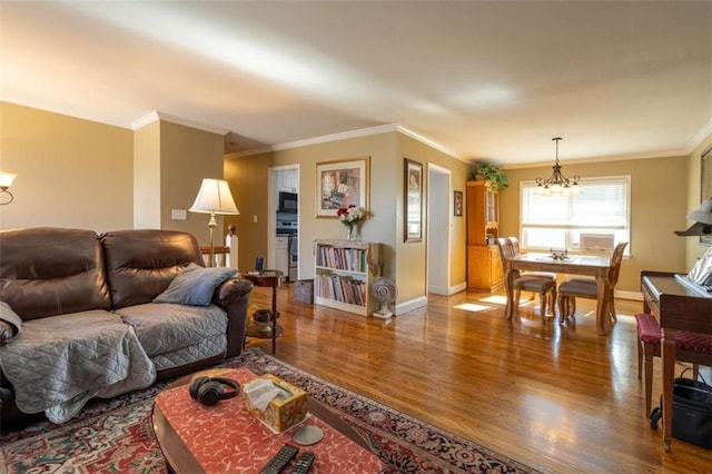 living room featuring hardwood / wood-style floors, a chandelier, and ornamental molding