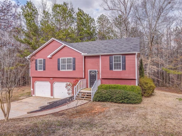 raised ranch with a garage and concrete driveway