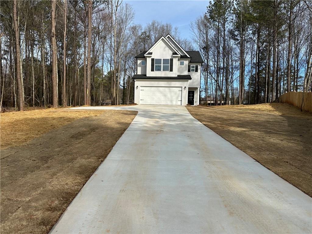 exterior space featuring board and batten siding, concrete driveway, and an attached garage