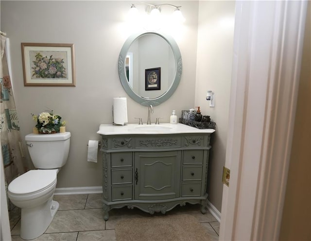 bathroom with toilet, vanity, and tile patterned floors