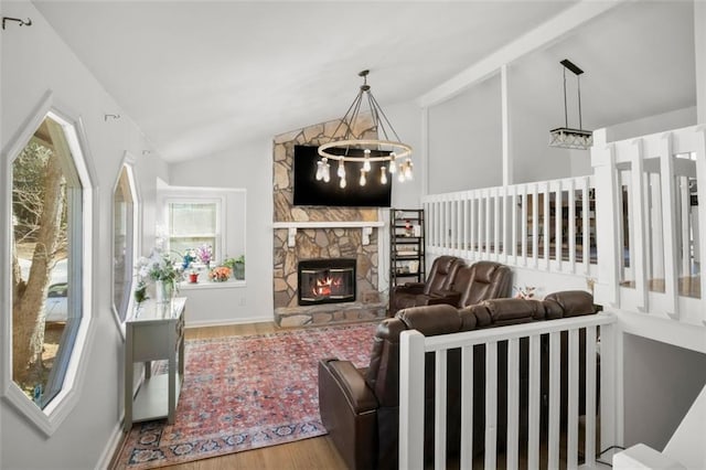 living room featuring wood-type flooring, lofted ceiling with beams, a chandelier, and a fireplace