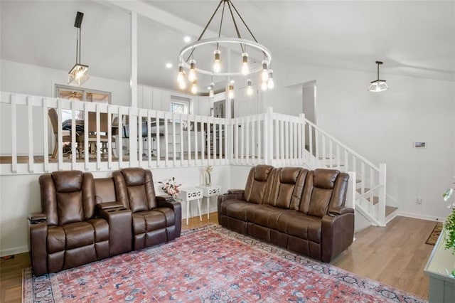 living room featuring light wood-type flooring, an inviting chandelier, and lofted ceiling