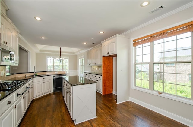 kitchen featuring black appliances, a peninsula, a sink, crown molding, and a chandelier