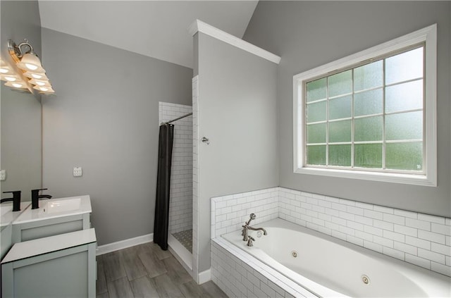bathroom featuring a jetted tub, a shower stall, vanity, baseboards, and lofted ceiling
