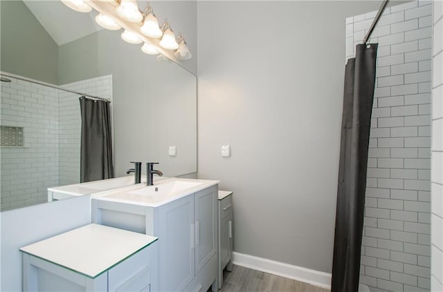 full bathroom featuring vanity, tiled shower, wood finished floors, and a chandelier