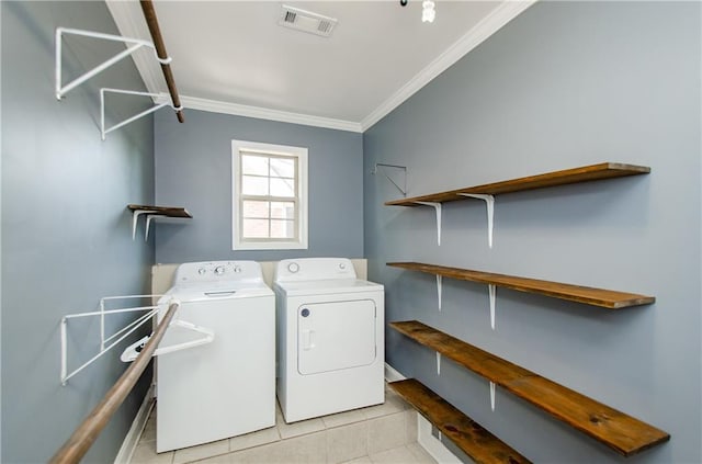 clothes washing area featuring washer and clothes dryer, ornamental molding, light tile patterned floors, and baseboards