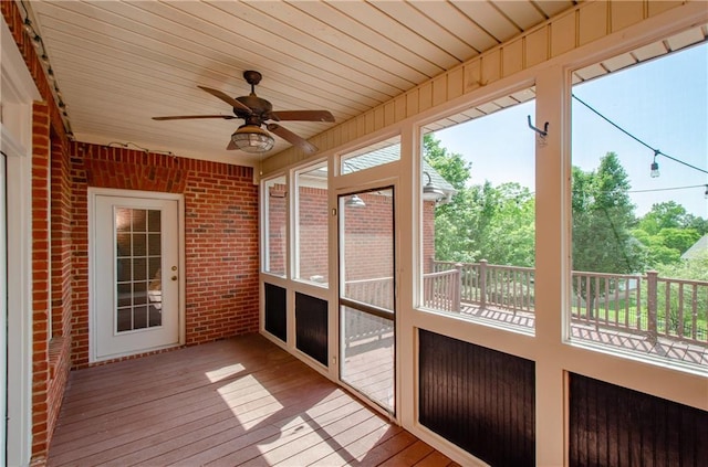 unfurnished sunroom featuring a ceiling fan and healthy amount of natural light