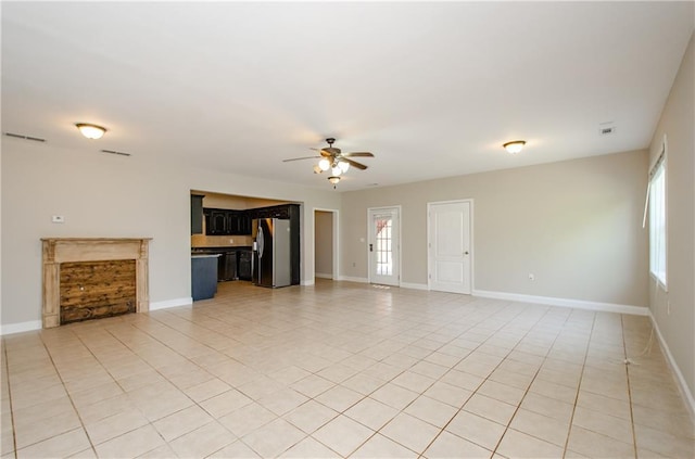 unfurnished living room featuring light tile patterned flooring, ceiling fan, and baseboards