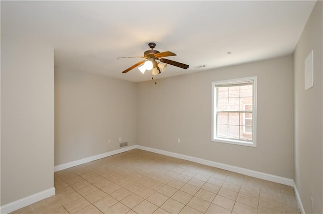 empty room featuring a ceiling fan, light tile patterned floors, and baseboards