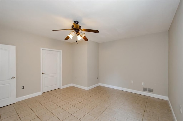 spare room featuring ceiling fan, light tile patterned flooring, and baseboards