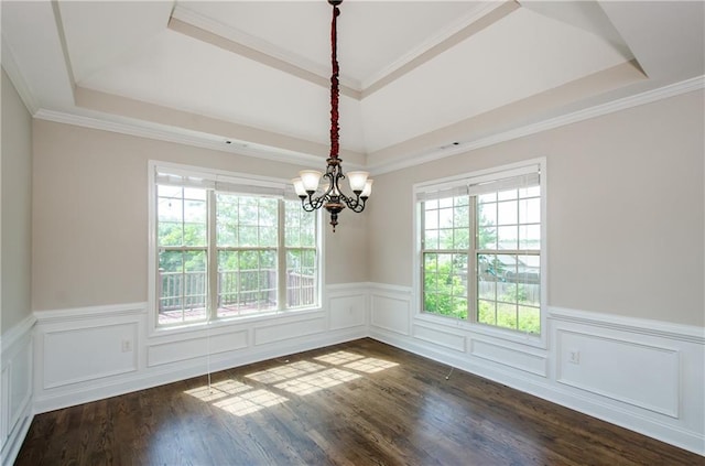 empty room with a raised ceiling, a chandelier, a wainscoted wall, dark wood-type flooring, and crown molding