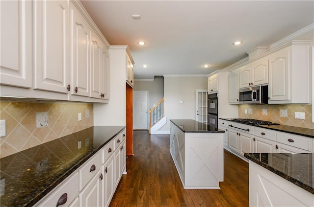 kitchen featuring black appliances, crown molding, dark wood-type flooring, white cabinetry, and decorative backsplash