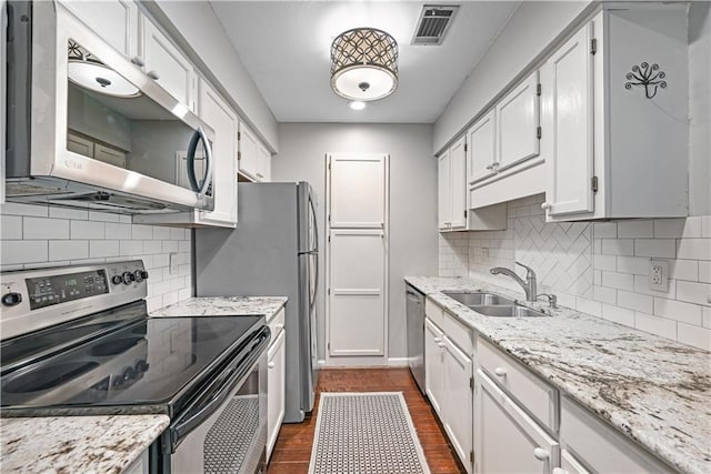 1312 Pine Heights Dr NE, Atlanta, GA 30324 - kitchen with stainless steel appliances, a sink, decorative backsplash, white cabinetry, and light stone counters