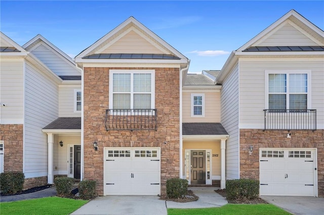 townhome / multi-family property featuring a standing seam roof, metal roof, concrete driveway, and roof with shingles