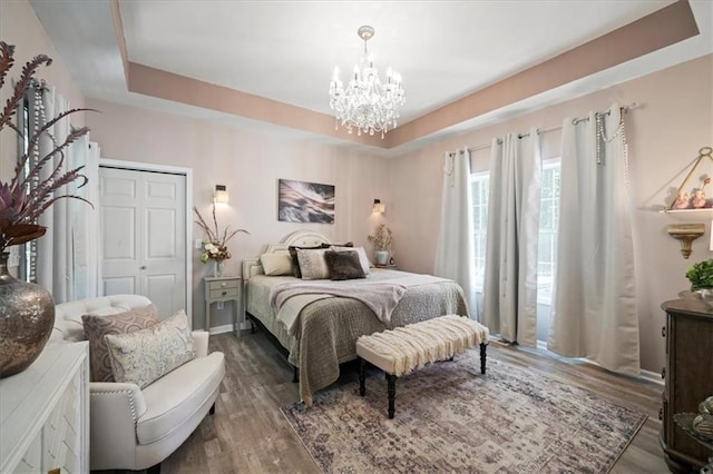 9050 Pine Tree Cir, Gainesville, GA 30506 - bedroom featuring a chandelier, wood finished floors, a closet, and a raised ceiling