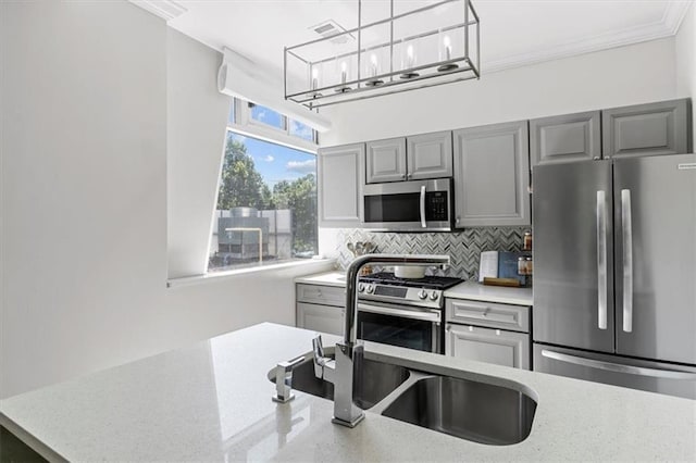2479 Peachtree Rd NE Unit 105, Atlanta, GA 30305 - kitchen featuring appliances with stainless steel finishes, gray cabinets, tasteful backsplash, hanging light fixtures, and crown molding