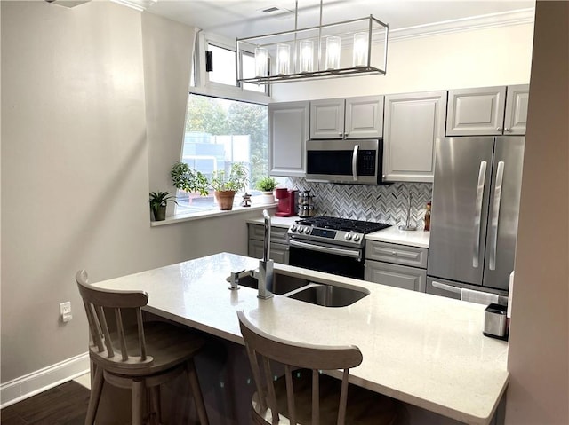 2479 Peachtree Rd NE Unit 105, Atlanta, GA 30305 - kitchen with appliances with stainless steel finishes, backsplash, gray cabinets, a kitchen bar, and crown molding