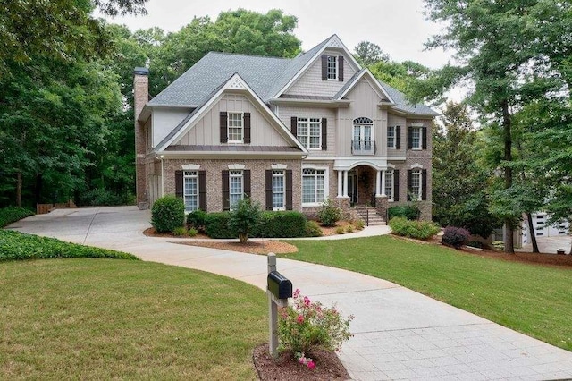 craftsman-style home with brick siding, board and batten siding, a chimney, and a front lawn