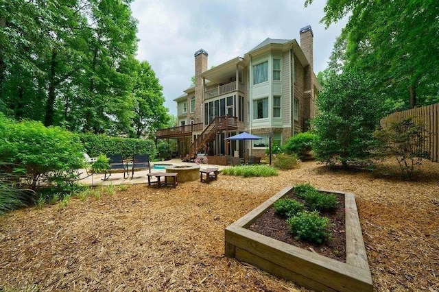 back of house with a patio, fence, stairway, a wooden deck, and a chimney