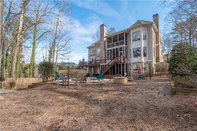 rear view of property with stairway, fence, a chimney, a deck, and a patio area