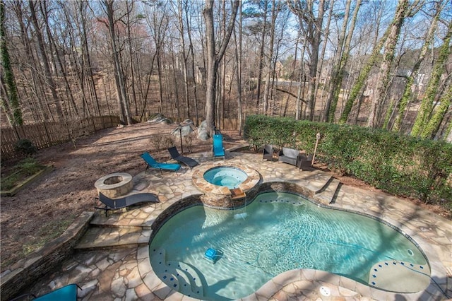 view of pool with a fenced in pool, a fire pit, fence, a patio area, and an in ground hot tub
