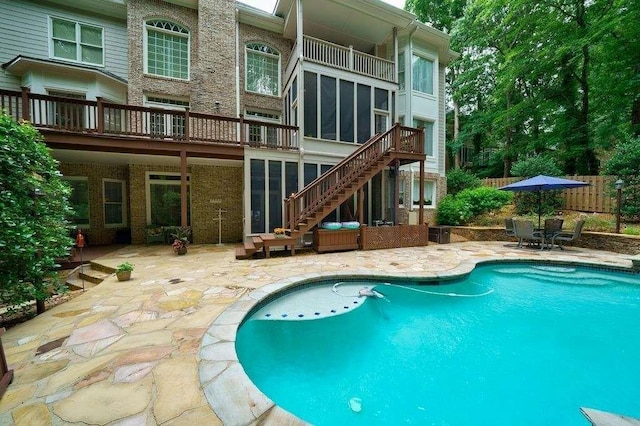 outdoor pool featuring stairway and a patio