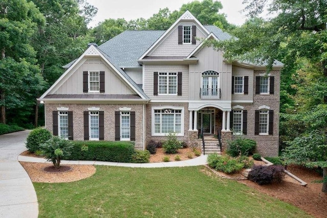 view of front of property with brick siding, board and batten siding, and a front yard