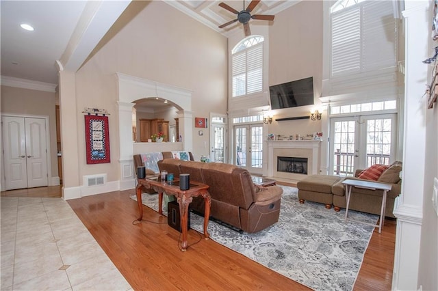 living room featuring visible vents, wood finished floors, ceiling fan, and ornamental molding