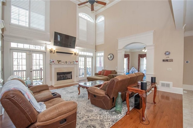 living room featuring visible vents, ornamental molding, french doors, ceiling fan, and ornate columns