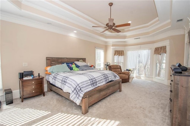 bedroom with light carpet, crown molding, and a raised ceiling