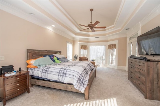 bedroom featuring light colored carpet, a raised ceiling, ceiling fan, and ornamental molding