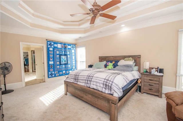 carpeted bedroom featuring a ceiling fan, a raised ceiling, crown molding, and baseboards