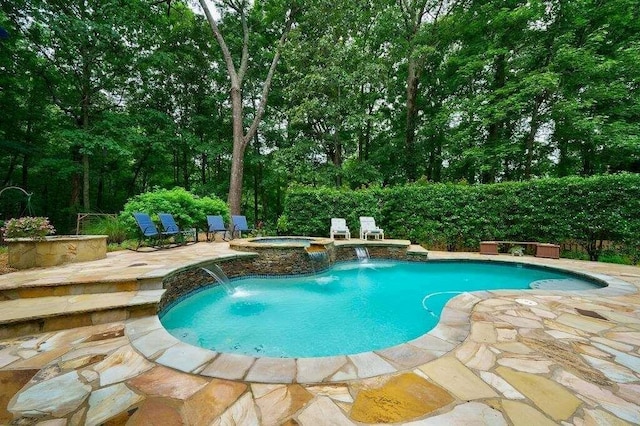 outdoor pool with a patio area and an in ground hot tub