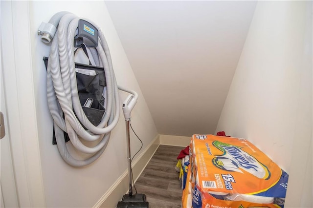 laundry room featuring baseboards and wood finished floors