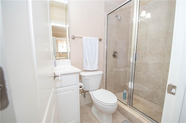 bathroom featuring tile patterned floors, toilet, a stall shower, and vanity